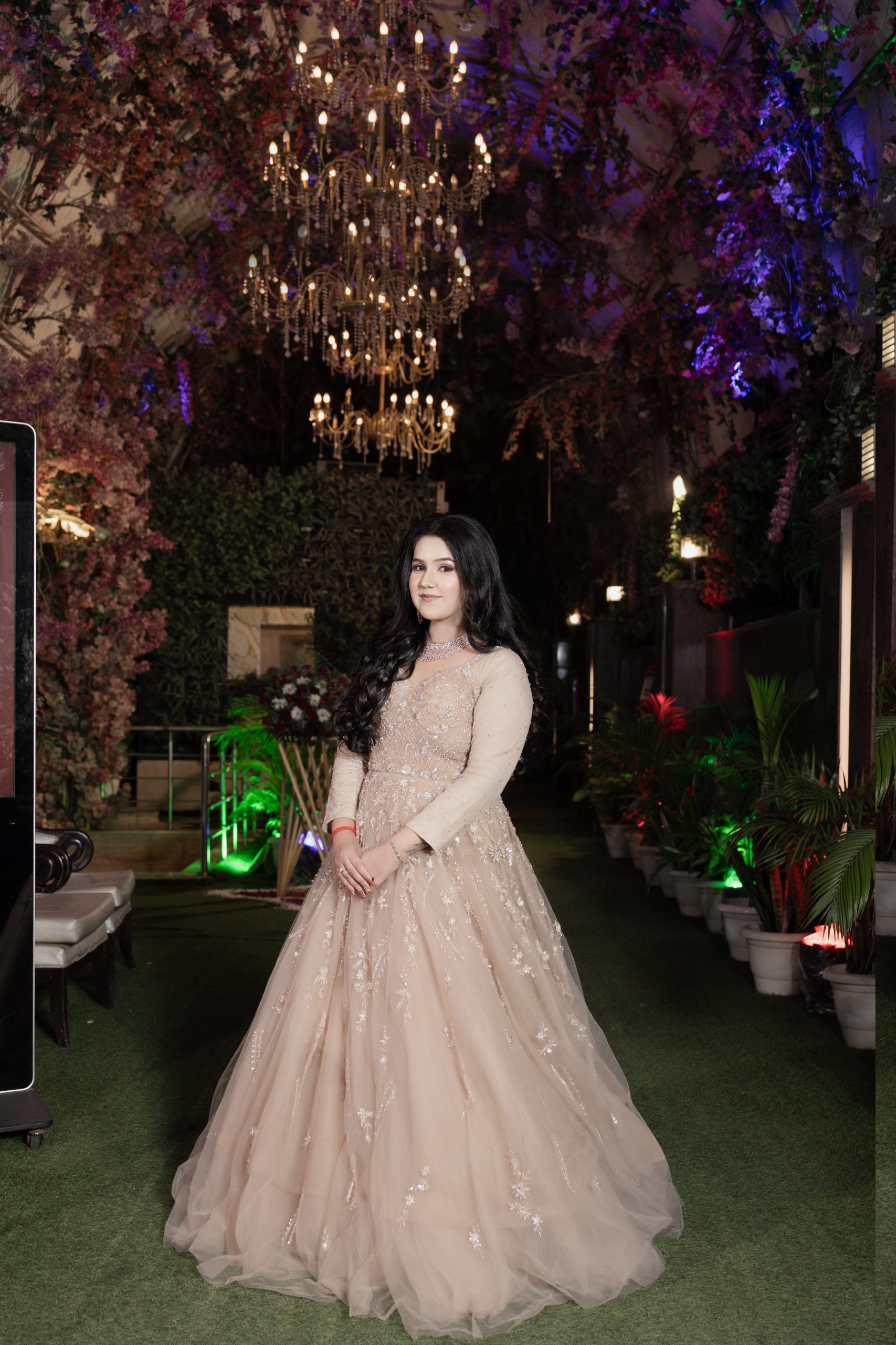 Bride posing in a garden at night in traditional wedding attire