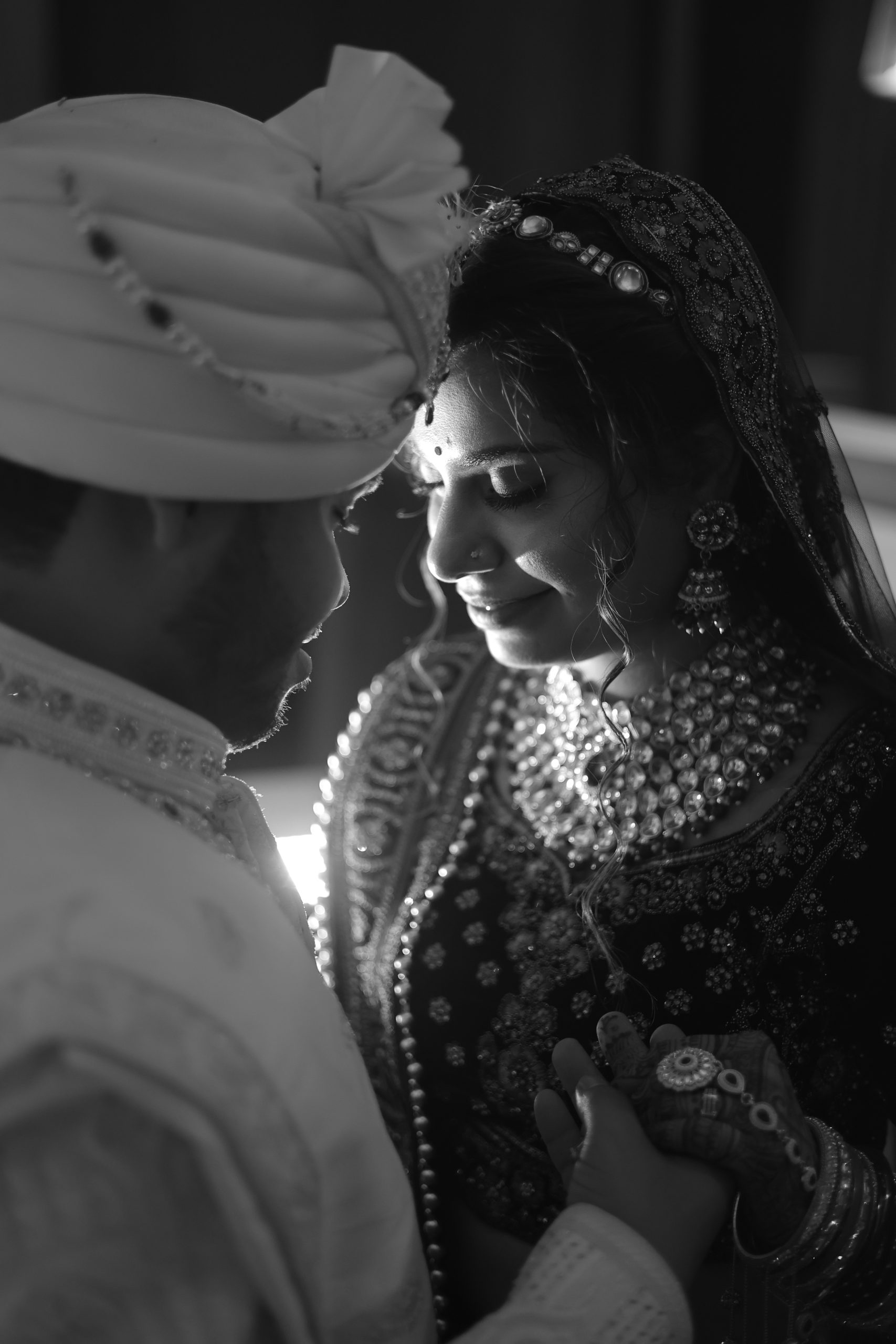 Black and white portrait of a bride and groom sharing an intimate wedding moment