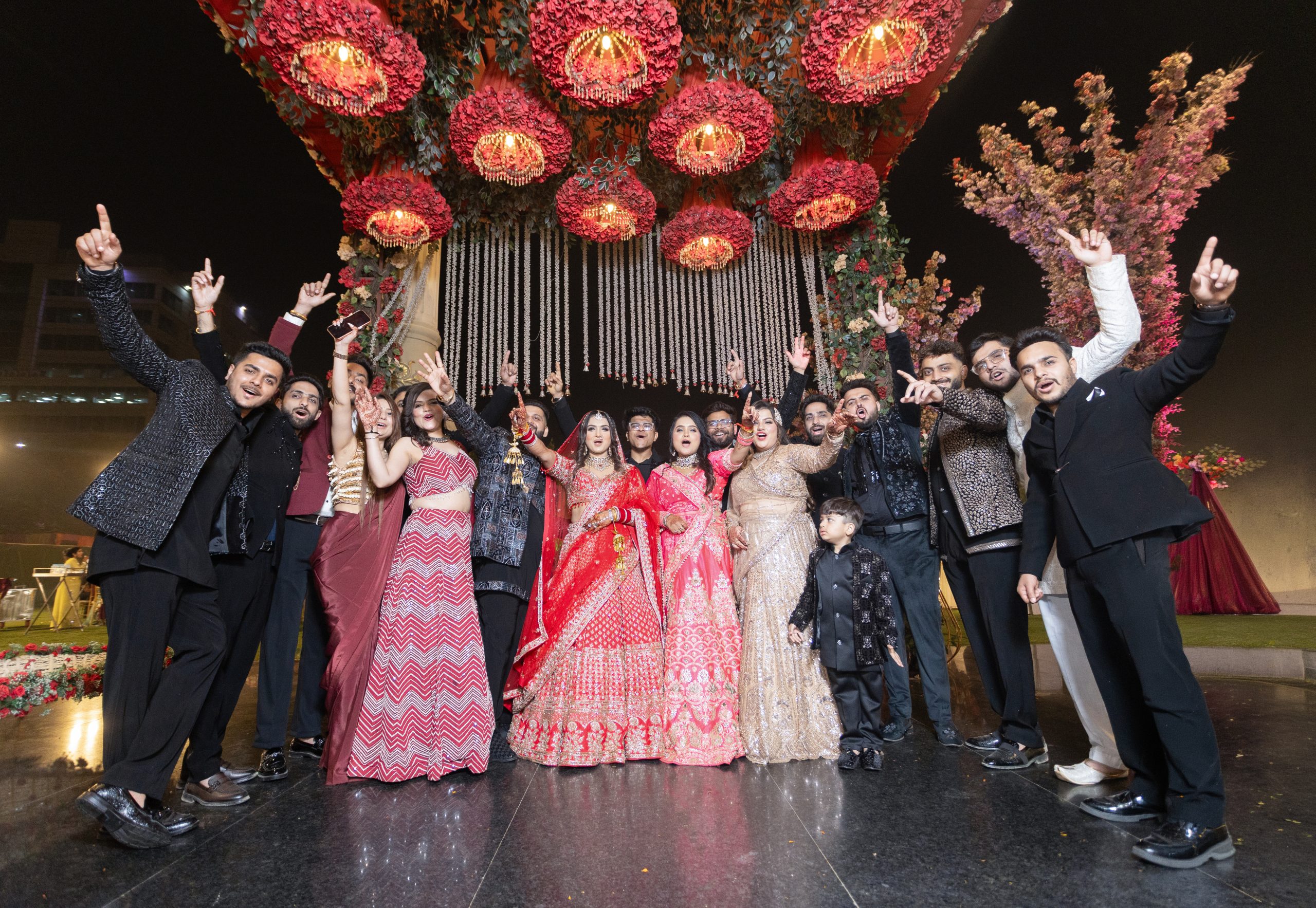 Wedding guests celebrating beneath decorative red hanging lights